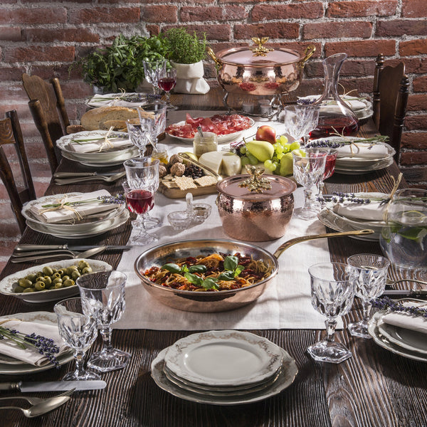 dinner table set with copper cookware for serving