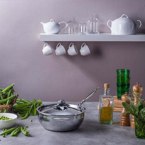 Stainless steel chef pan from Ruffoni in kitchen with veggies, herbs, and oil